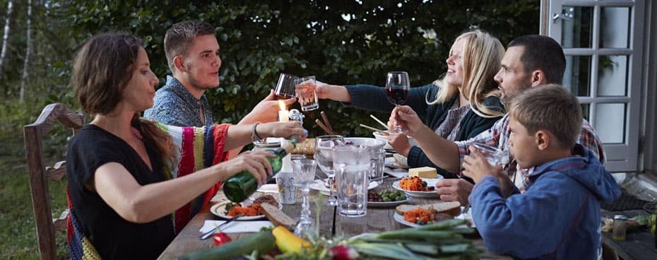 Samengesteld gezin buiten aan tafel.